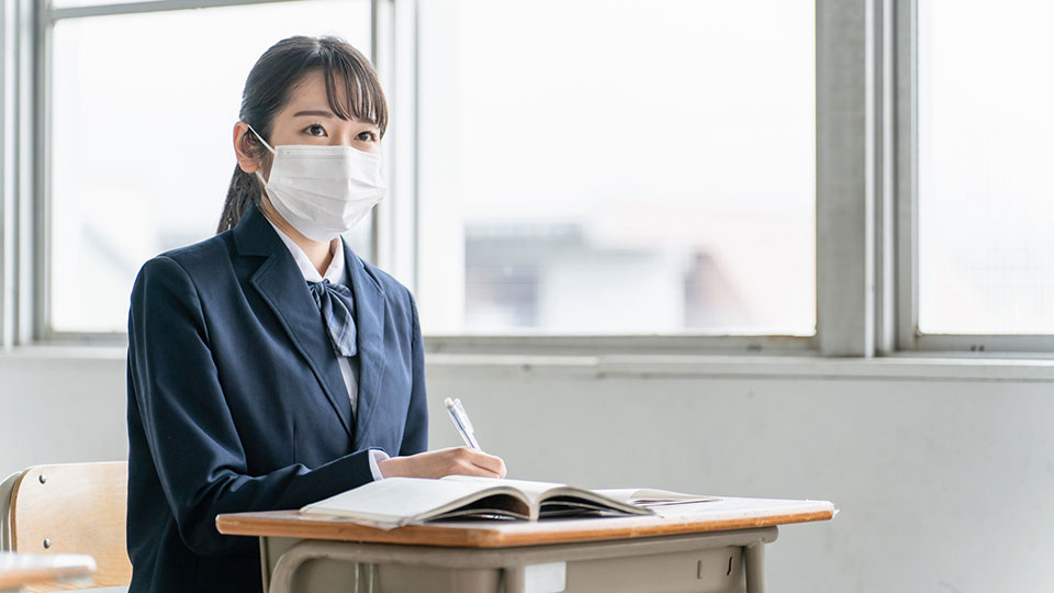 マスクをする学生のイメージ